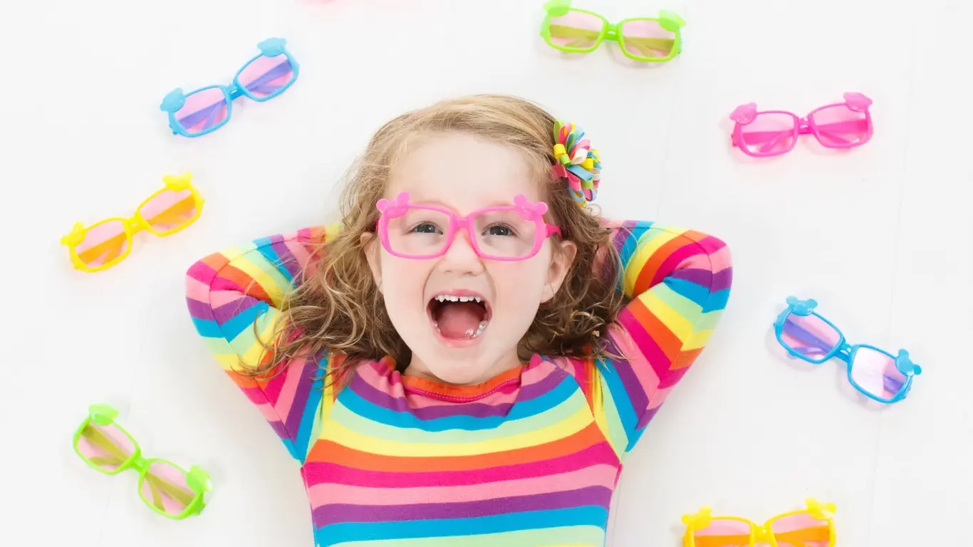 Niña feliz rodeada de monturas de colores
